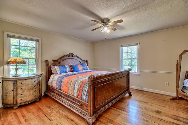 bedroom with baseboards, light wood-style flooring, and a textured ceiling