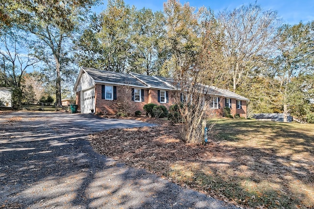 ranch-style home with a garage, driveway, and brick siding