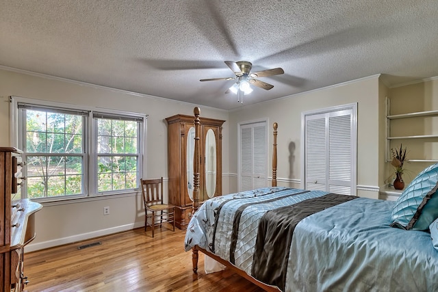 bedroom featuring visible vents, crown molding, and light wood finished floors