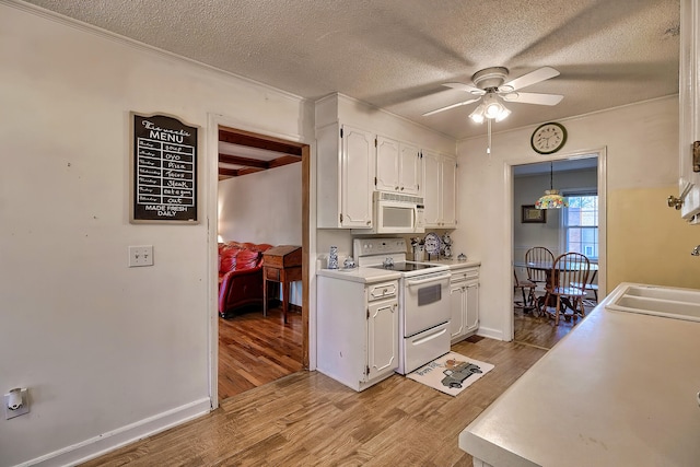 kitchen featuring light countertops, light wood-style flooring, white cabinetry, a sink, and white appliances