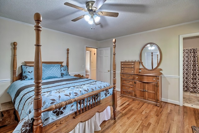 bedroom featuring light wood-type flooring, a textured ceiling, and crown molding