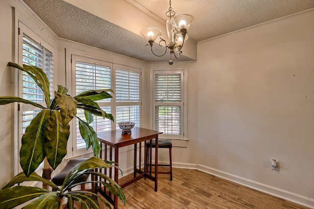 office space featuring a textured ceiling, ornamental molding, wood finished floors, and a wealth of natural light