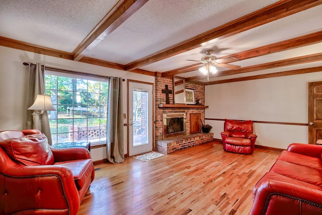 living area featuring a brick fireplace, light wood-style floors, a textured ceiling, and beamed ceiling