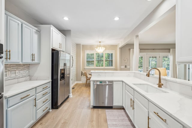 kitchen with stainless steel appliances, sink, hanging light fixtures, and white cabinets