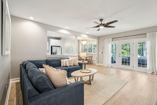 living room featuring ceiling fan and light hardwood / wood-style floors