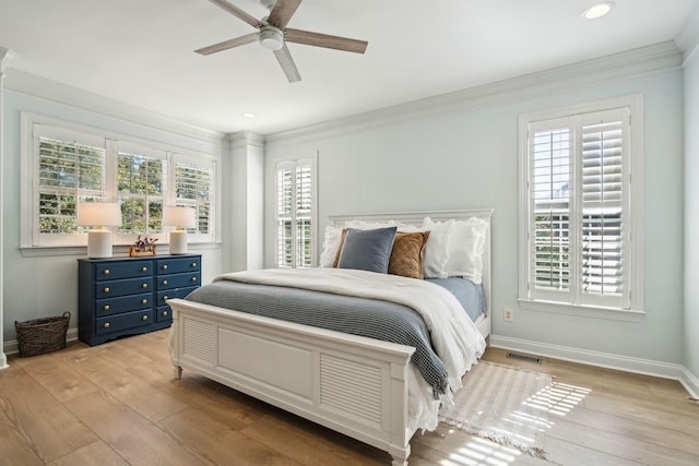 bedroom featuring multiple windows, light hardwood / wood-style flooring, and ornamental molding