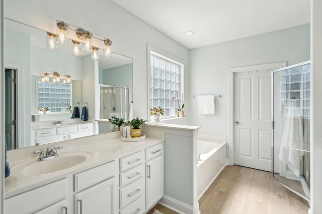 bathroom featuring independent shower and bath, vanity, and hardwood / wood-style floors