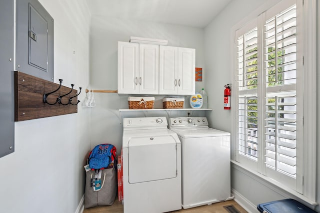 clothes washing area featuring cabinets and washer and clothes dryer