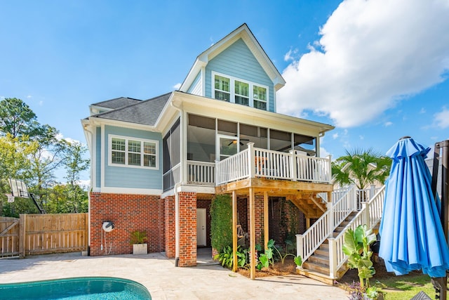 rear view of house with a fenced in pool, a sunroom, a patio, and ceiling fan