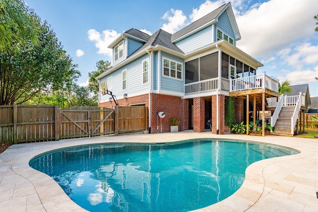 view of pool with a deck and a sunroom