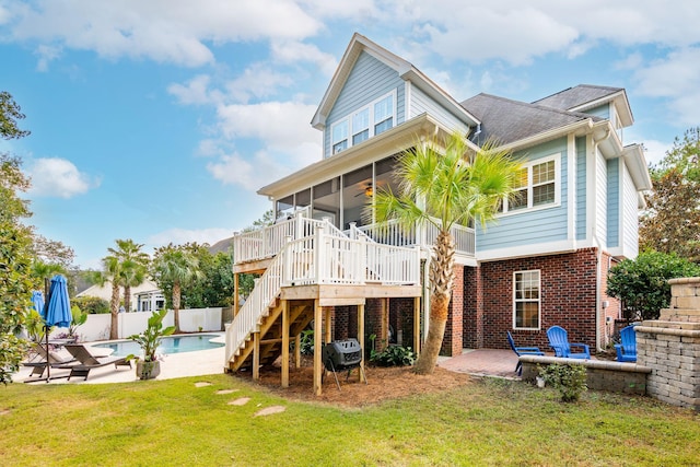 rear view of house featuring a lawn, a sunroom, a patio, and ceiling fan