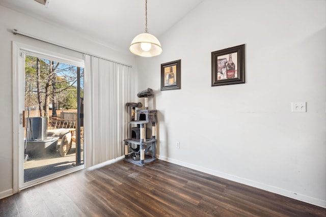 empty room featuring vaulted ceiling and dark hardwood / wood-style flooring