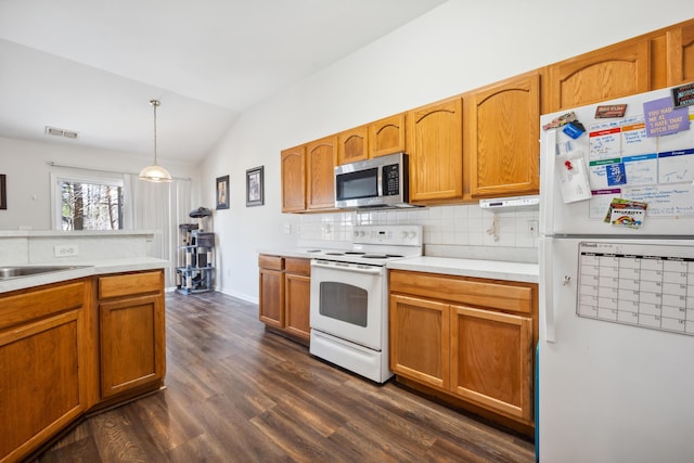 kitchen featuring dark wood-type flooring, lofted ceiling, pendant lighting, white appliances, and decorative backsplash