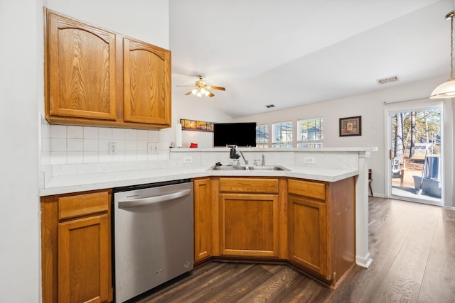 kitchen featuring lofted ceiling, sink, dishwasher, decorative light fixtures, and kitchen peninsula