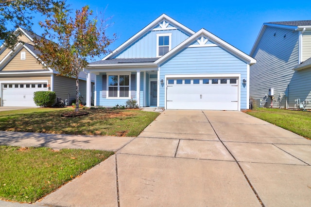 craftsman inspired home featuring a garage and a front lawn