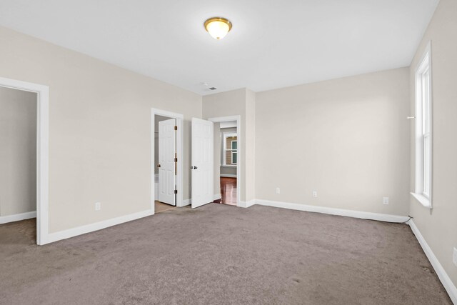 unfurnished bedroom with multiple windows and carpet floors