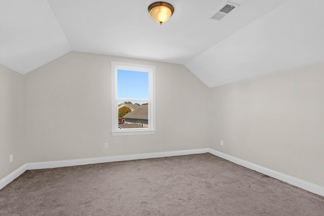 additional living space featuring carpet flooring and vaulted ceiling