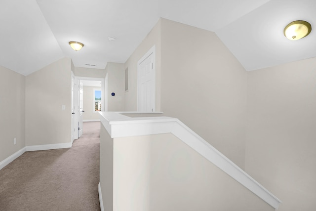 corridor with light carpet and vaulted ceiling