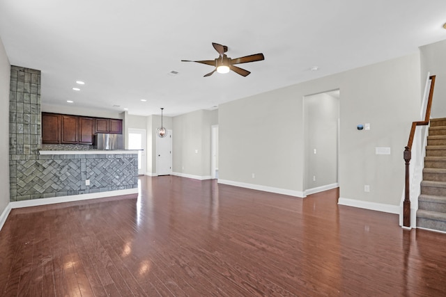 unfurnished living room featuring dark hardwood / wood-style floors and ceiling fan