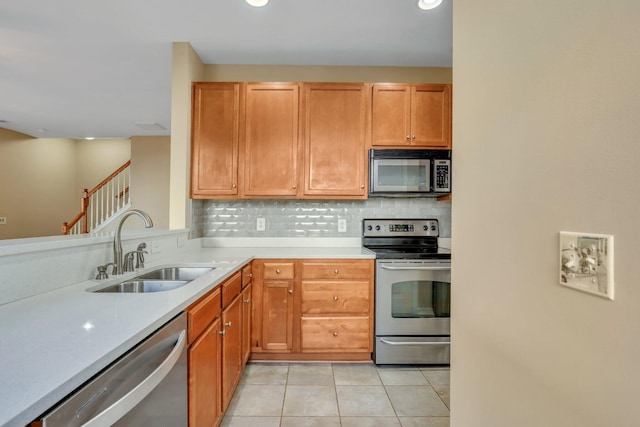 kitchen featuring light tile patterned floors, backsplash, stainless steel appliances, and sink