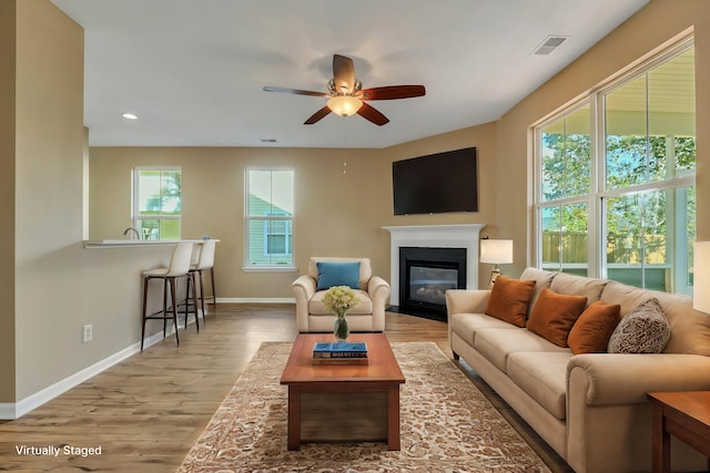 living room with light wood-type flooring and ceiling fan