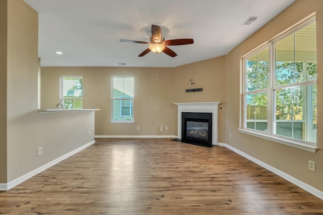 unfurnished living room with light hardwood / wood-style flooring and ceiling fan