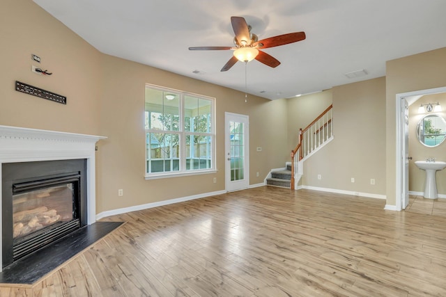 unfurnished living room with light hardwood / wood-style flooring, ceiling fan, and sink