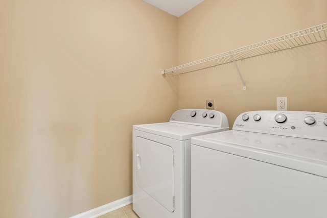 laundry area with washer and clothes dryer and light tile patterned flooring