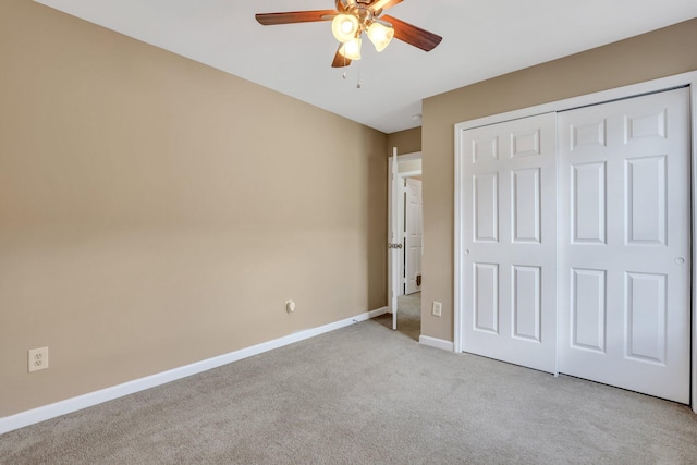 unfurnished bedroom with ceiling fan, light carpet, and a closet