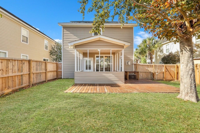 rear view of house with a yard and a wooden deck