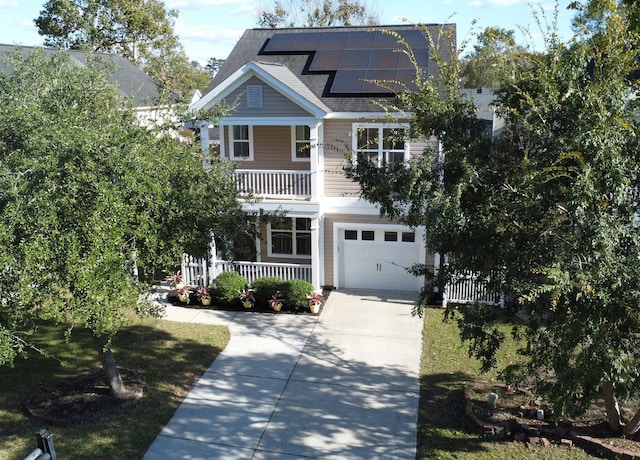 view of front of property with covered porch, solar panels, and a garage