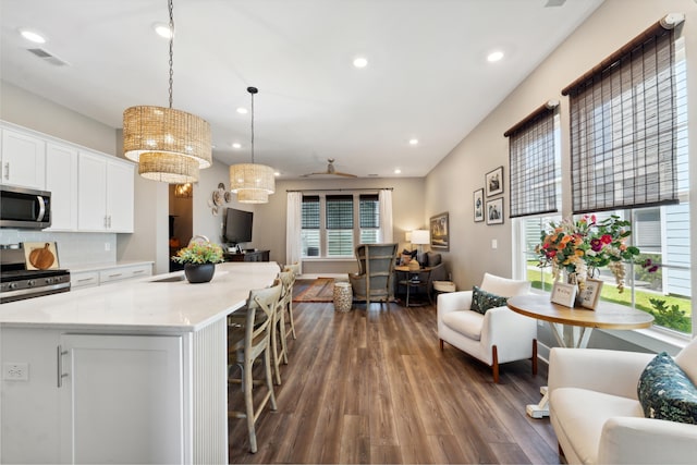 kitchen with pendant lighting, white cabinets, a healthy amount of sunlight, and appliances with stainless steel finishes