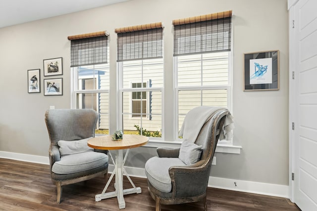 living area featuring breakfast area and dark wood-type flooring