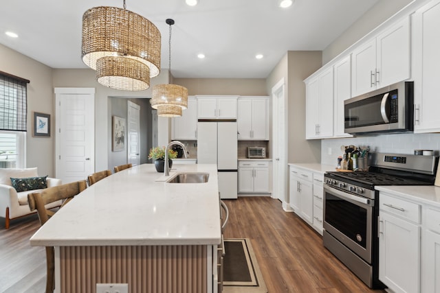 kitchen featuring a kitchen island with sink, pendant lighting, and appliances with stainless steel finishes