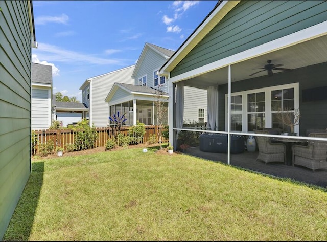 view of yard featuring a sunroom and ceiling fan