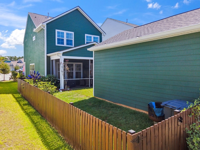 back of house featuring a sunroom and a yard