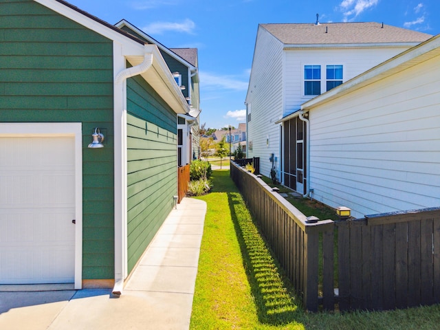 view of side of property featuring a lawn and a garage