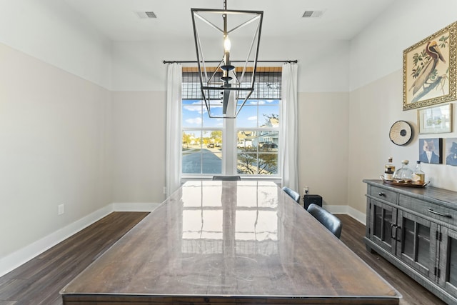 dining space featuring dark hardwood / wood-style flooring and a chandelier