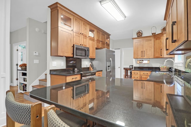 kitchen featuring stainless steel appliances, sink, a kitchen breakfast bar, and kitchen peninsula