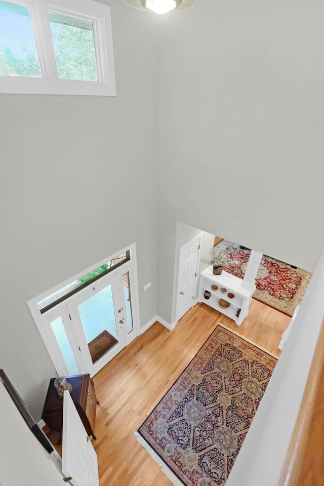 foyer featuring a towering ceiling and hardwood / wood-style floors