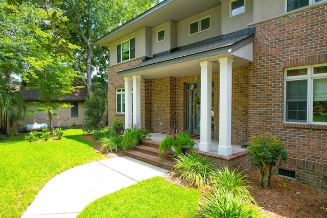 view of exterior entry featuring a yard