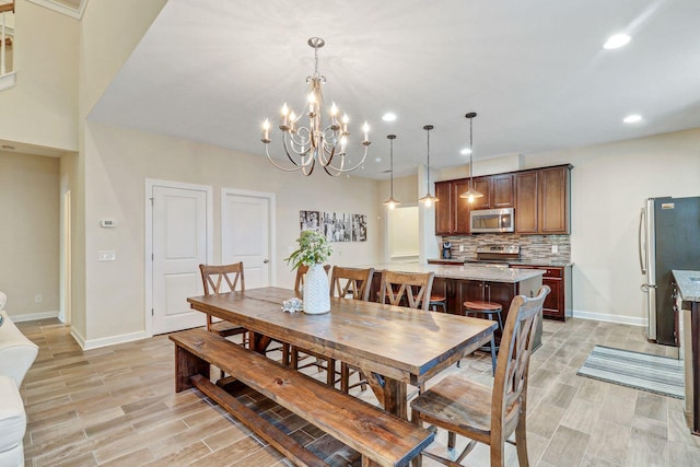 dining space with a notable chandelier and light hardwood / wood-style flooring