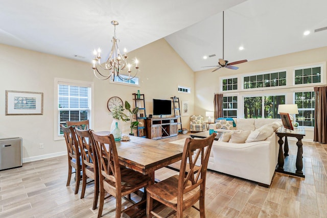 dining area featuring ceiling fan with notable chandelier, high vaulted ceiling, and light hardwood / wood-style flooring