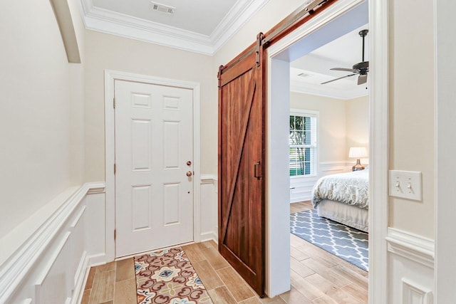 235 Club Gate, Bluffton, SC 29910 - entrance foyer with visible vents, a barn door, wood finish floors, ornamental molding, and wainscoting