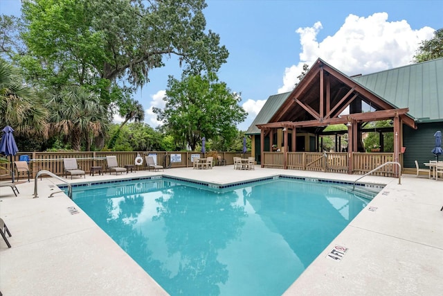 pool with a patio area and fence