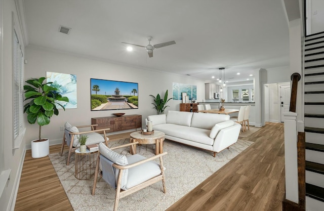 living area with ceiling fan, recessed lighting, light wood-type flooring, visible vents, and stairway