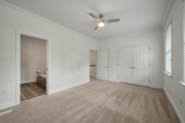 unfurnished bedroom with carpet floors, baseboards, crown molding, and a closet