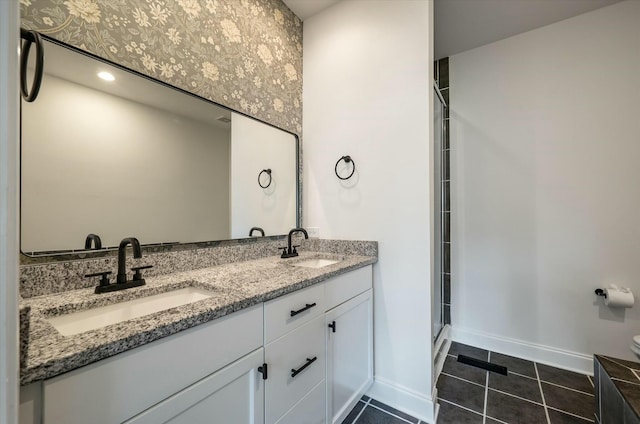 bathroom with baseboards, a sink, tile patterned floors, and a stall shower