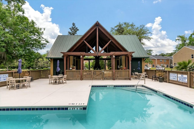 community pool with a gazebo, a patio area, and outdoor dining space