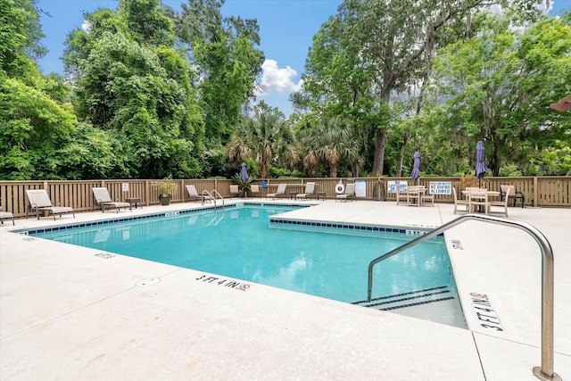 pool featuring fence and a patio